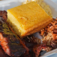 Barbecue spare ribs, red beans and rice, macaroni and cheese and cornbread in foam container